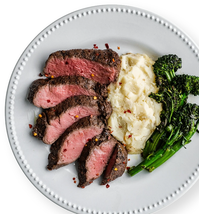 Plated steak dinner with mashed potatoes and broccolini