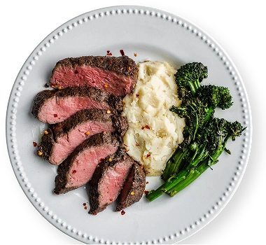 Plated steak dinner with mashed potatoes and broccolini