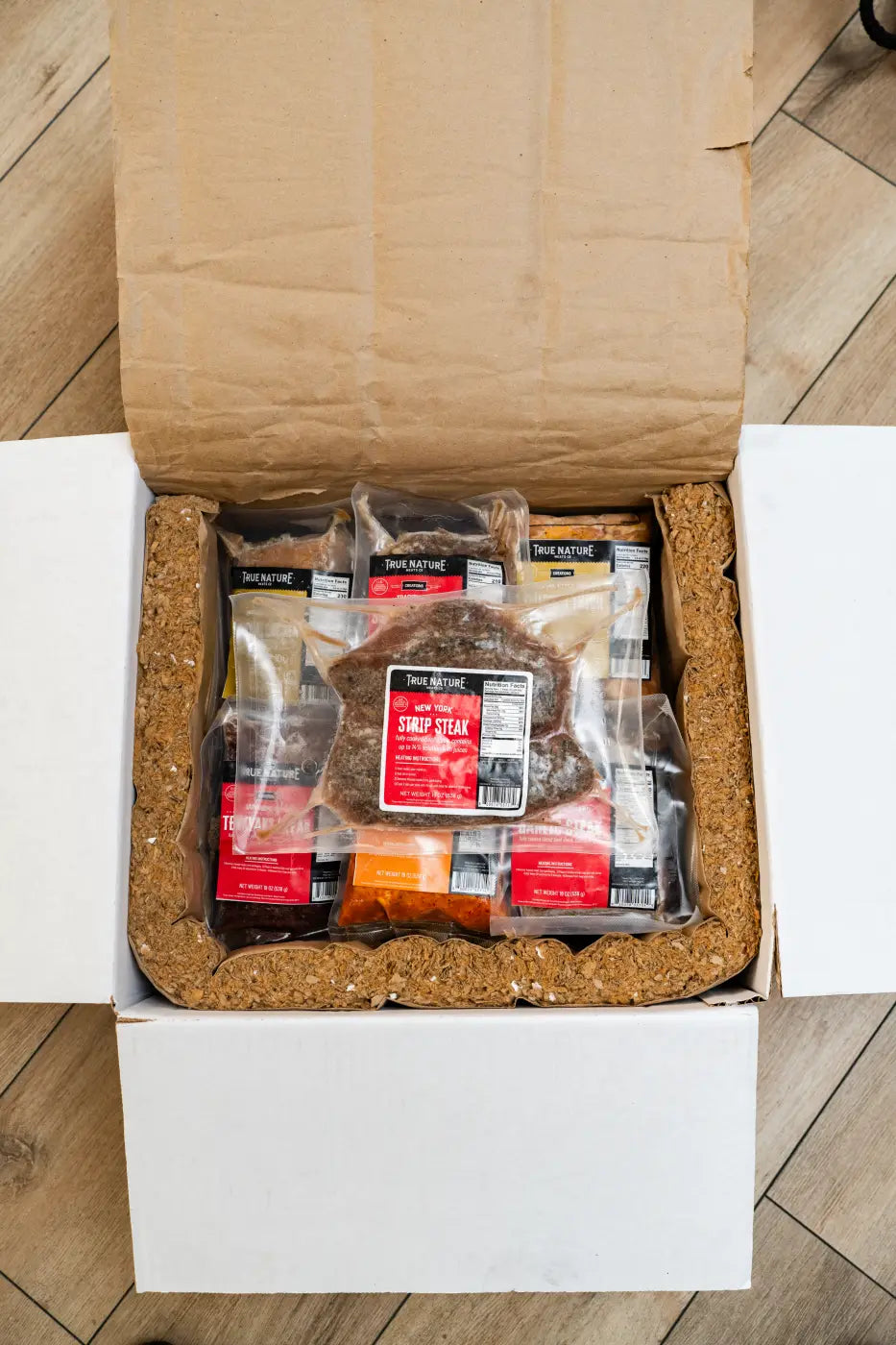 Opened insulated True Nature Meats delivery box with vacuum-sealed packs